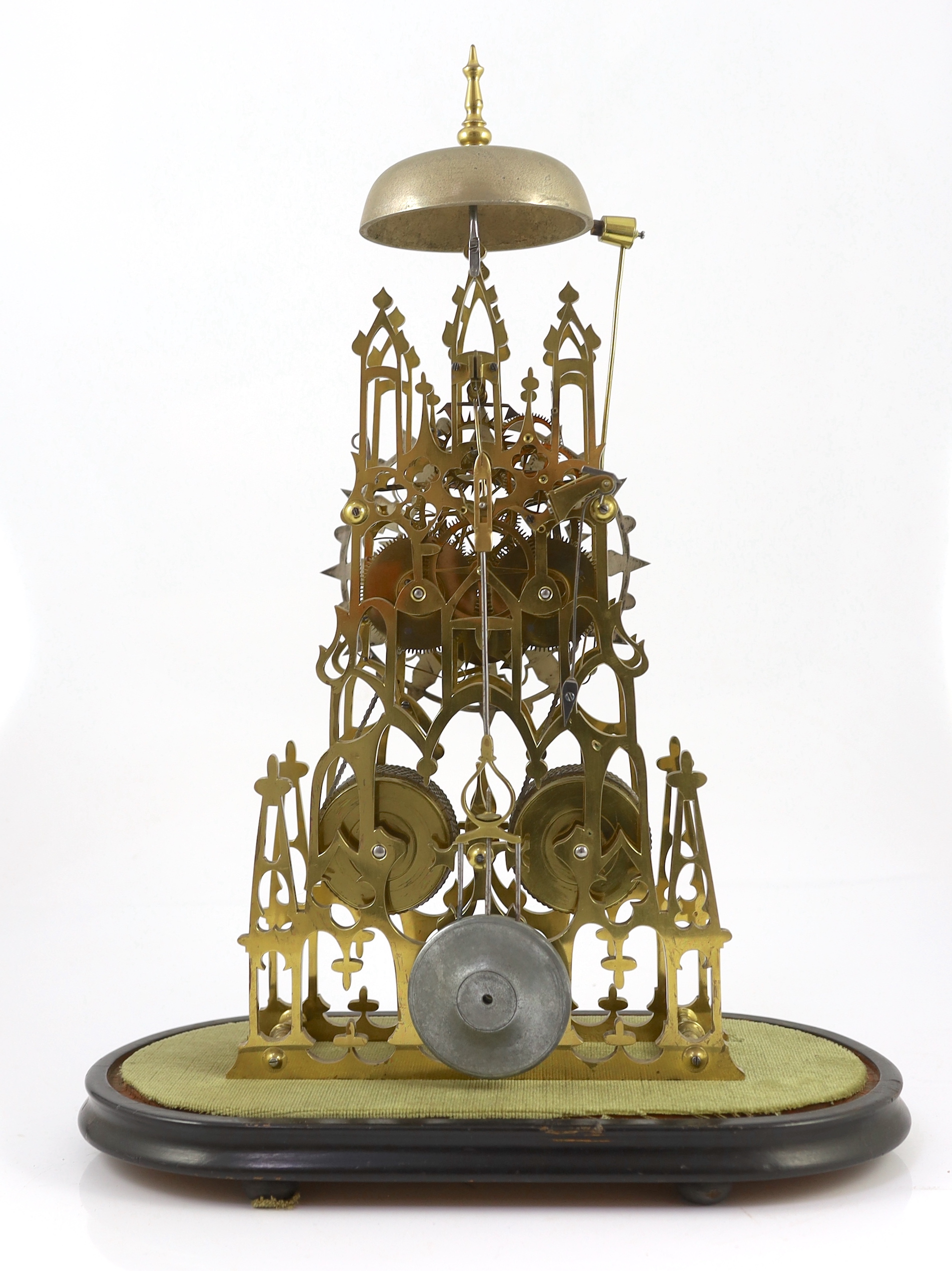 A Victorian brass cathedral skeleton clock, 46cm high, with ebonised stand and glass dome, overall 52cm high